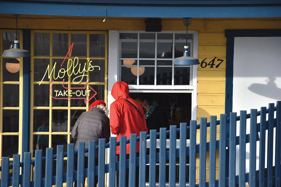 Diners order from the freshly installed takeout window at Molly’s Reach restaurant in Gibsons on March 31, the day rules banning indoor dining at pubs, bars and restaurants came into effect in B.C.