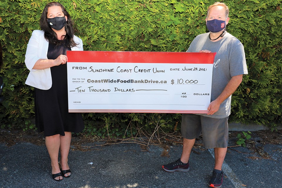 Darrell Pilgrim of the Salvation Army accepts $10,000 from Jodi Fichtner on behalf of the Sunshine Coast Credit Union.