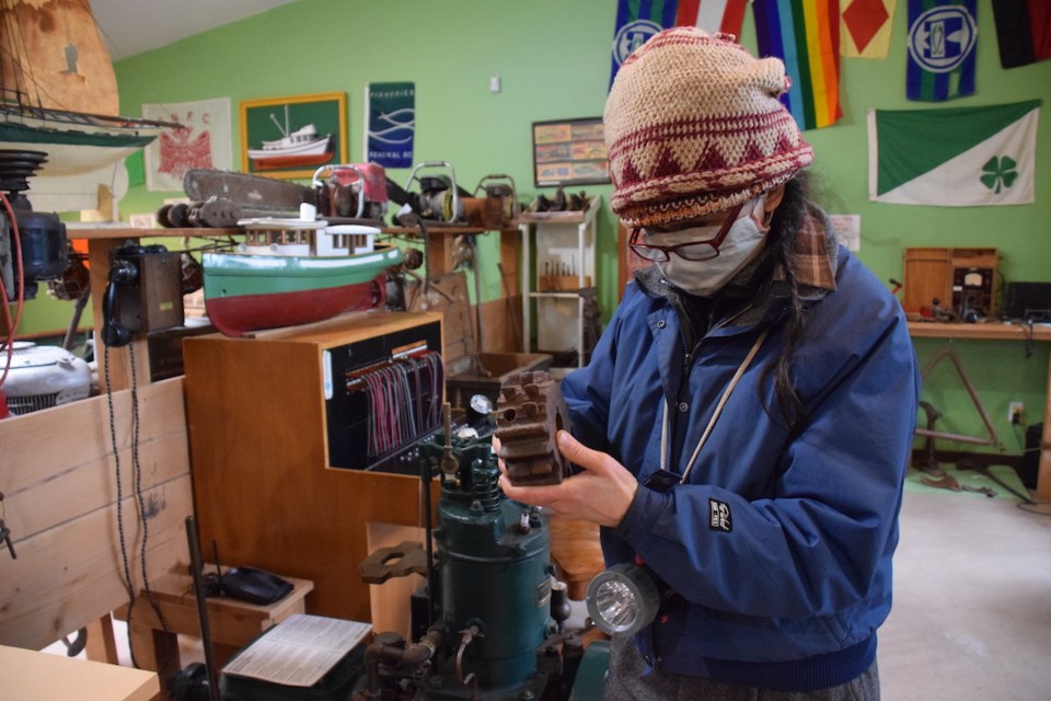 Maureen Juffs holds one of her favourite artifacts, a handmade tool, in the Egmont Heritage Centre’s collection.