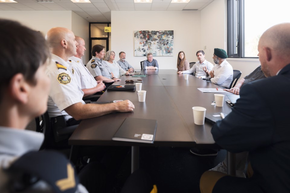 members-of-rcmp-fire-department-scrd-district-of-sechelt-sit-at-table-with-harjit-sajjan