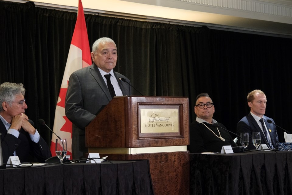 shíshálh Nation hiwus Warren Paull speaks at the Jan. 21 announcement that the Government of Canada will create a $2.8-billion trust for 325 Indigenous nations affected by residential schools. To the right sit former Tk’emlúps te Secwepemc chief Shane Gottfriedson and Crown-Indigenous Affair Minister March Miller.