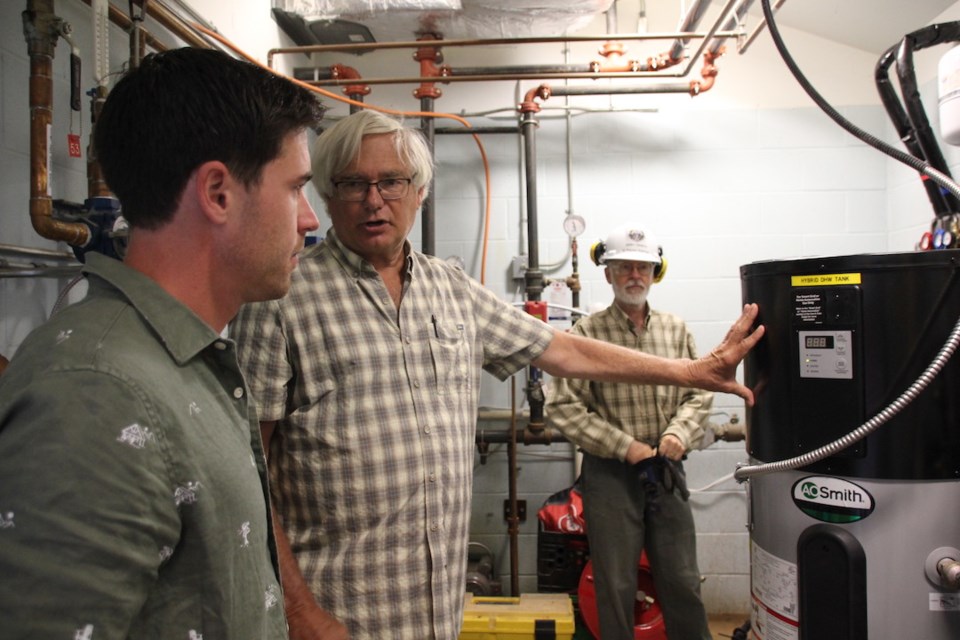 Gordon Bishop (centre) and Gerry Pageau (right) give MP Patrick Weiler a tour of the Sunshine Coast SPCA's new solar heat pump. 
