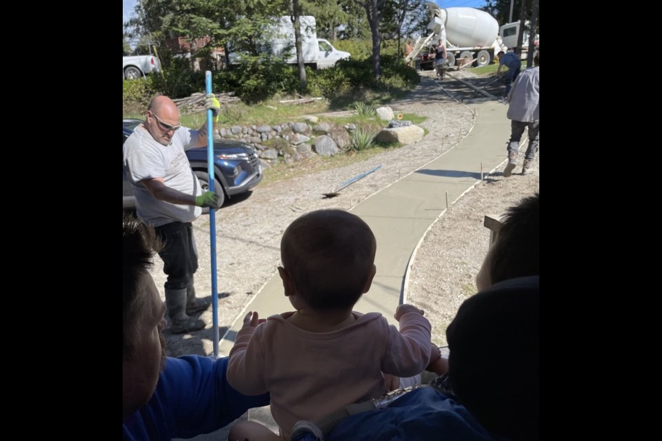 Ethan Shannon and his baby sister, Mila, watch Swanson’s Concrete and Denis Turenne Concrete building a path to the house. 