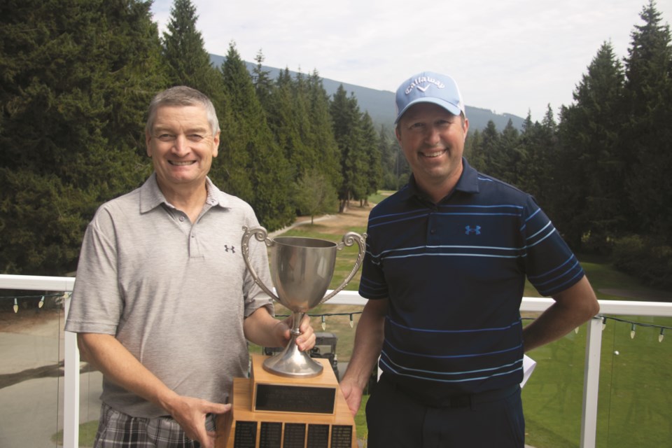 Sneddon receives his trophy from club professional Jim Pringle, standing on the right.