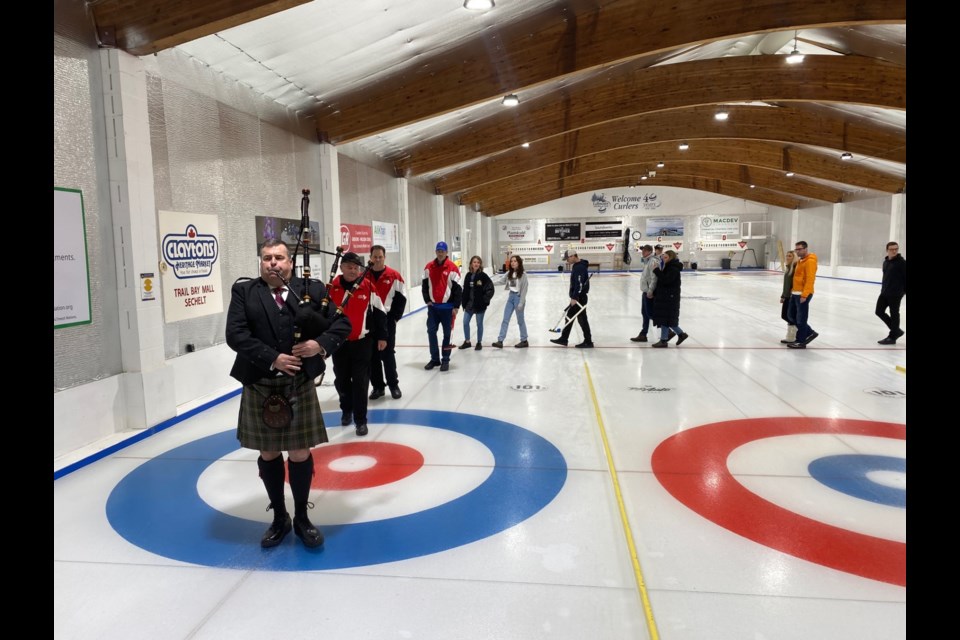 Jared Wannamaker's family and bonspiel curlers are piped onto the ice. 