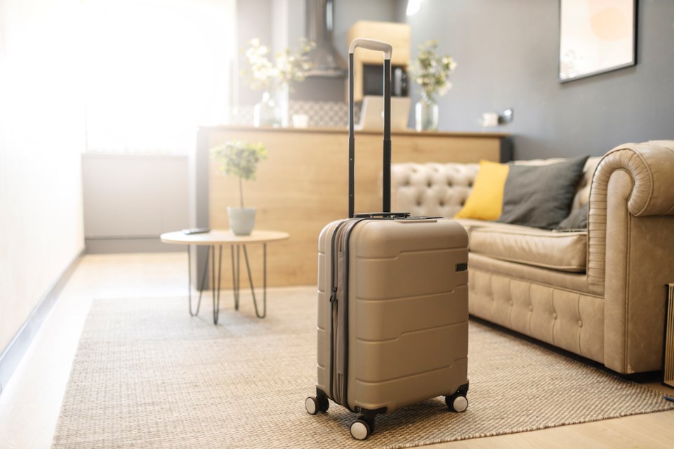 contemporary-plastic-suitcase-prepared-for-journey-placed-on-floor-in-living-room-at-home