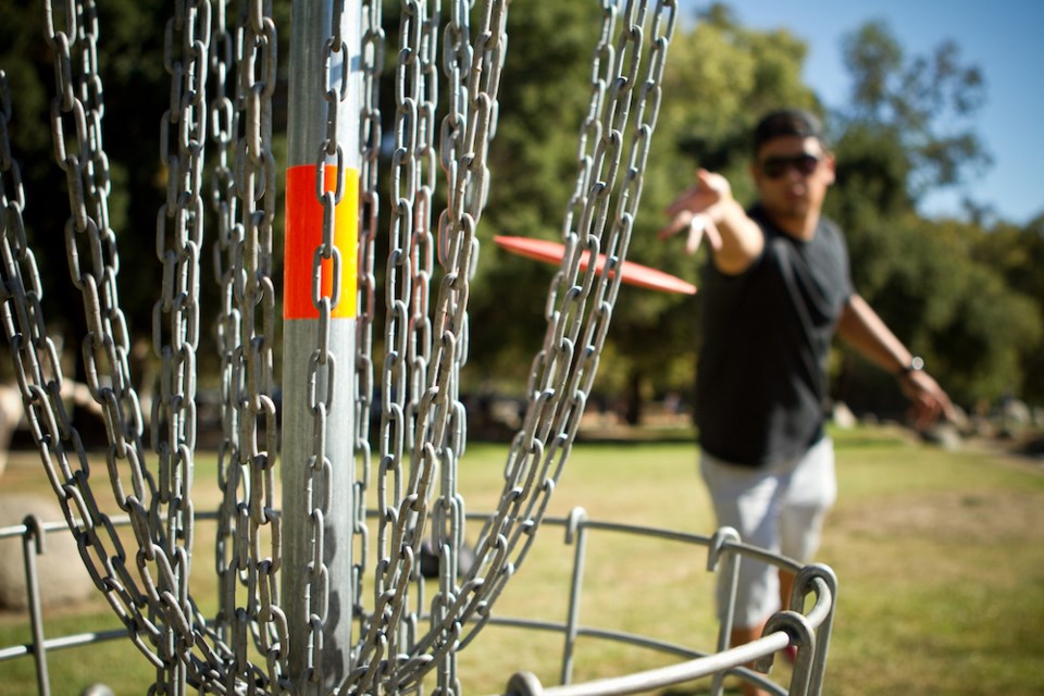 disc-golfer-releases-disc-towards-the-basket-for-a-successful-putt