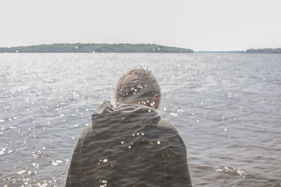 double exposure of boy looking over ocean