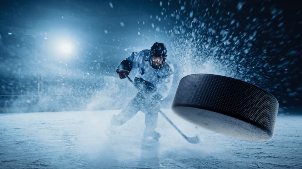 Hockey Player Shooting the Puck with Hockey Stick