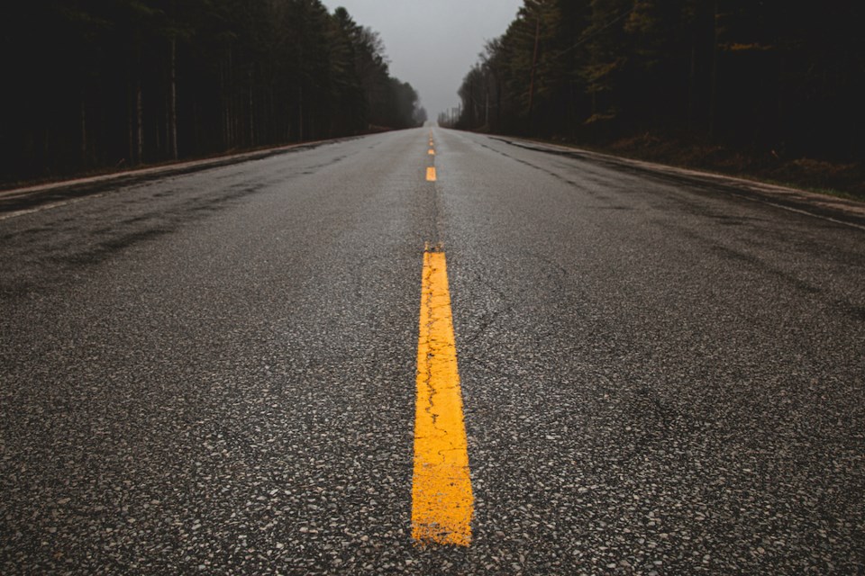 Low profile image of open roadway through a forest