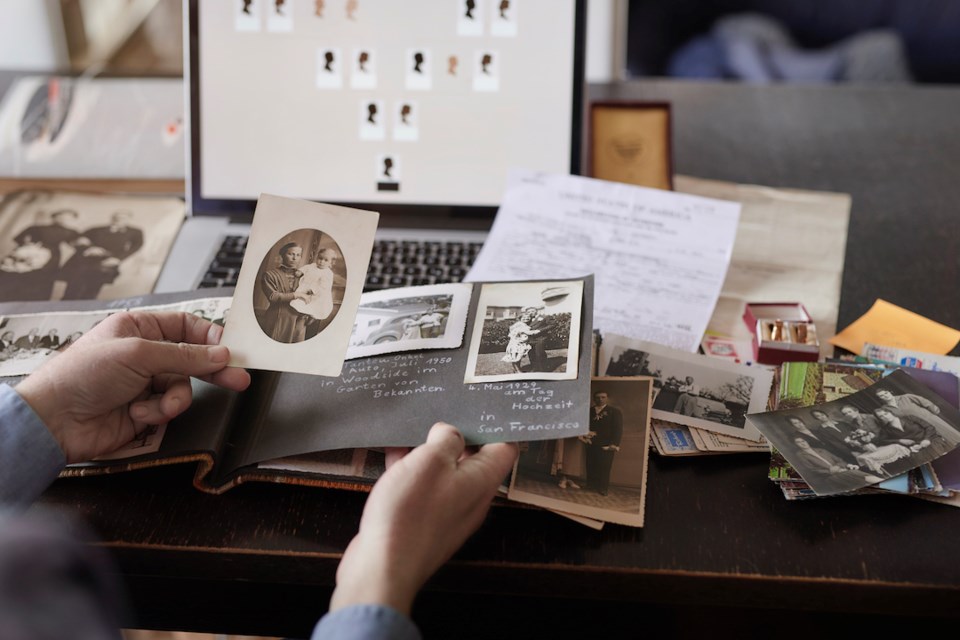 man-sitting-at-table-doing-research-on-family-members-on-computer-for-family-tree