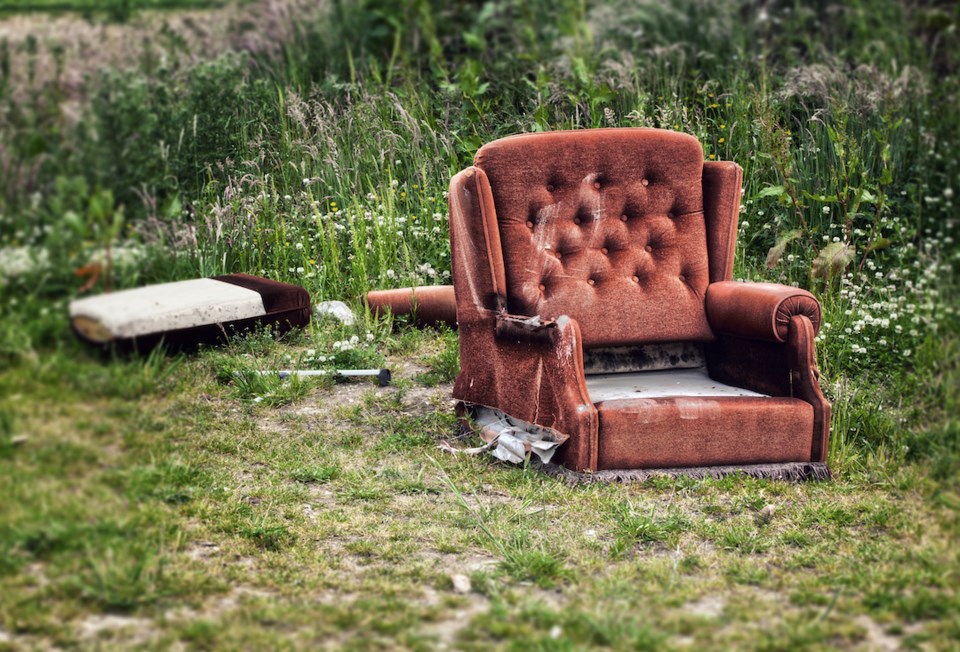 Old shabby damaged armchair outside