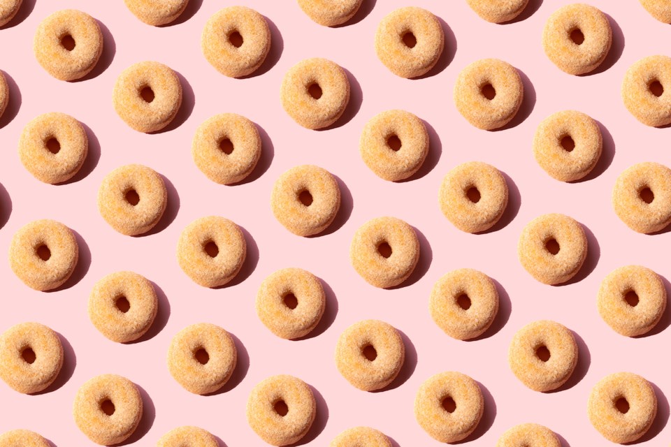 Rows of doughnuts against a pink backdrop
