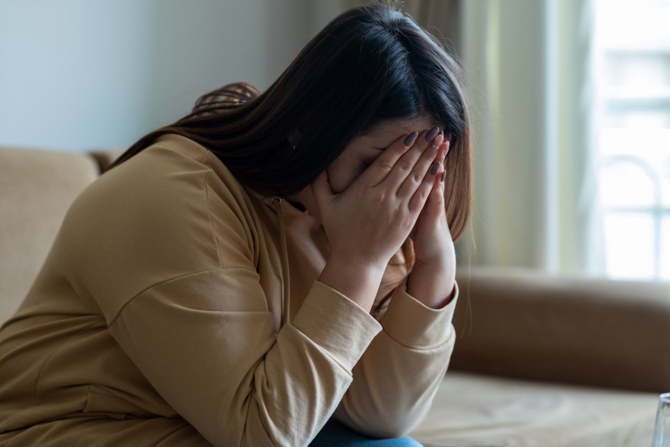 Sad woman sitting on a sofa in the living room