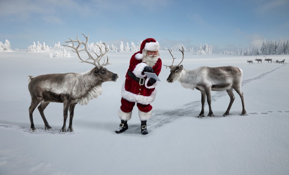 Santa and two reindeer looking at a tablet