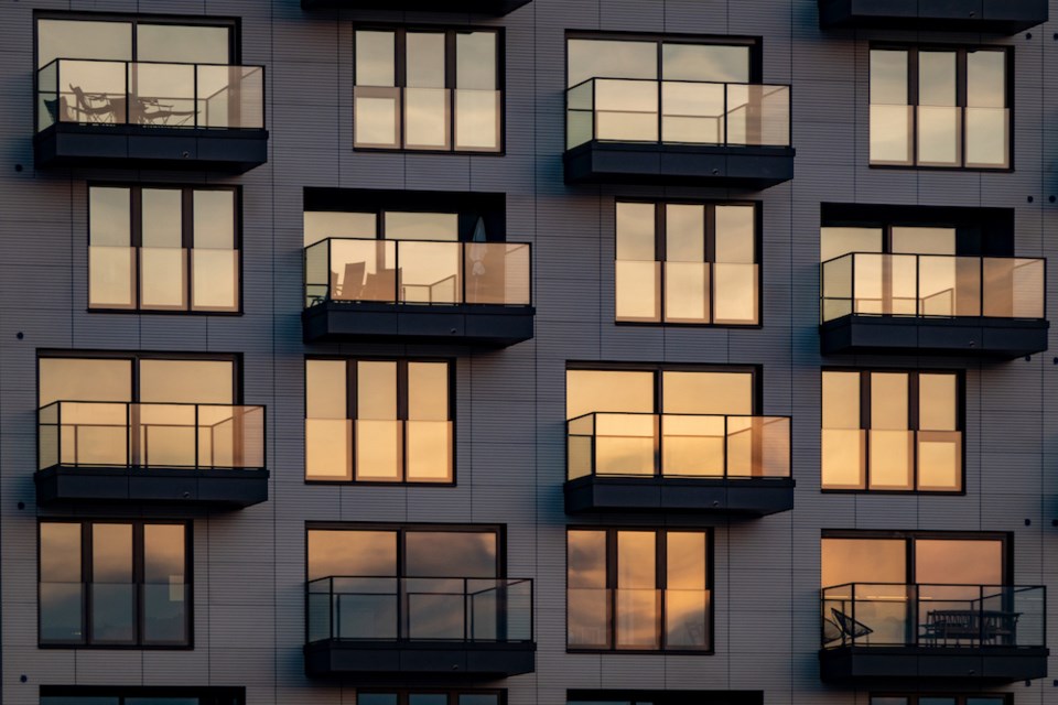 the-evening-sun-is-reflected-in-the-modern-glass-facade-with-balconies