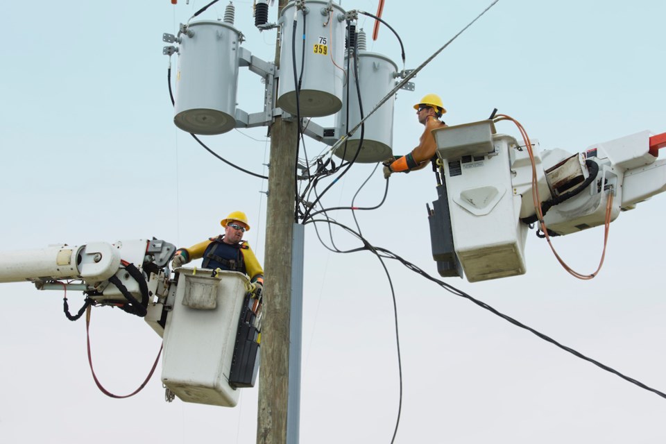 Workers in cherry pickers repairing power line
