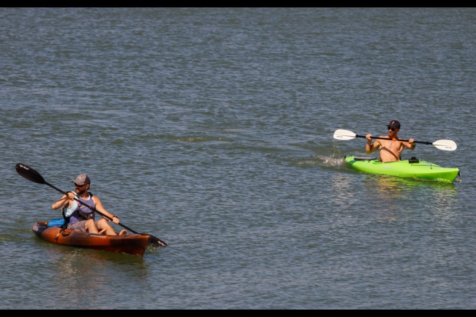 Kayakers ride along Ghost Lake on Saturday (May 16). (Chelsea Kemp/The Cochrane Eagle)