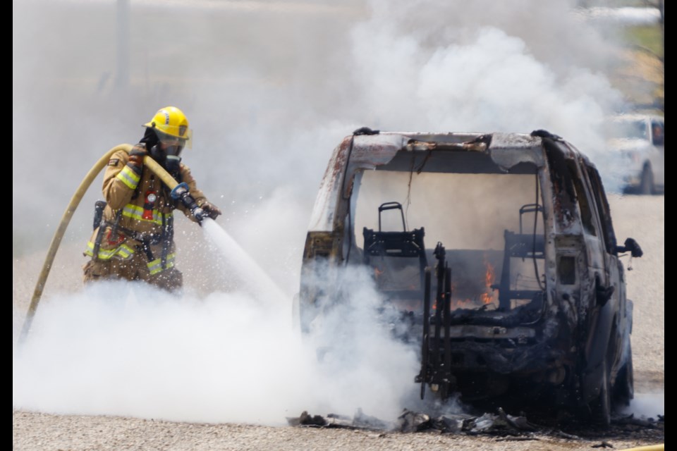 Rocky View Fire & Emergency and Cochrane Fire Services members respond to a vehicle fire on Towers Trail on Friday (May 29). (Chelsea Kemp/The Cochrane Eagle)