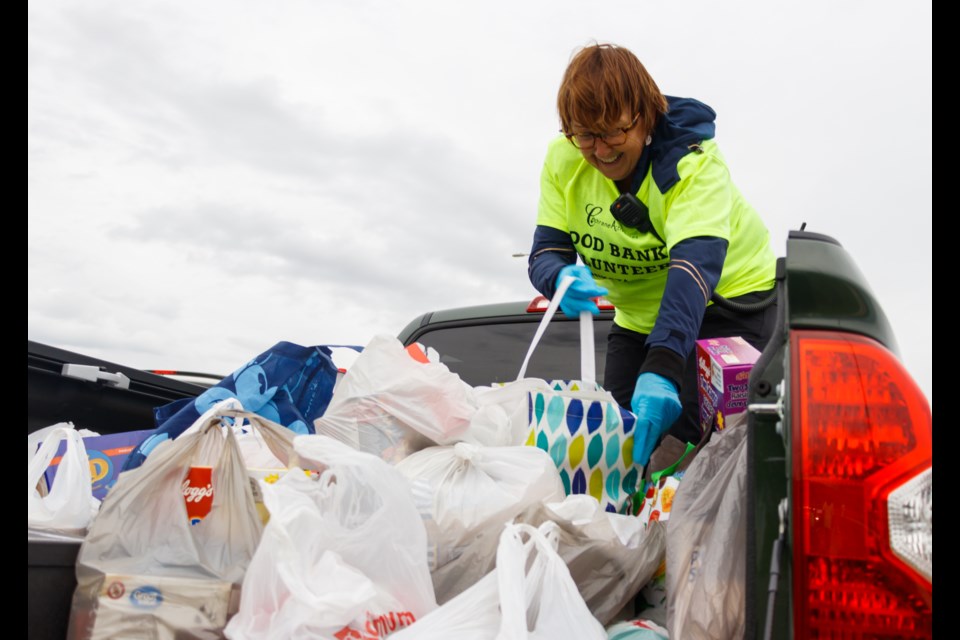 Cochrane Activette Marcia Gilbertson collects food at the “Movie Under the Stars” event at the Spray Lake Sawmills Family Sports Centre parking lot on Saturday (June 6). (Chelsea Kemp/The Cochrane Eagle)