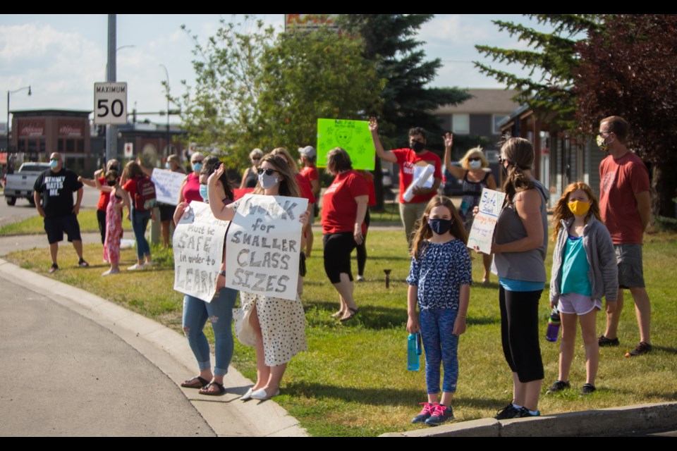 Teachers and Families for Safe School Re-Entry protesters gather outside Airdrie-Cochrane MLA Peter Guthrie's office on Wednesday (Aug. 19). (Chelsea Kemp/The Cochrane Eagle)