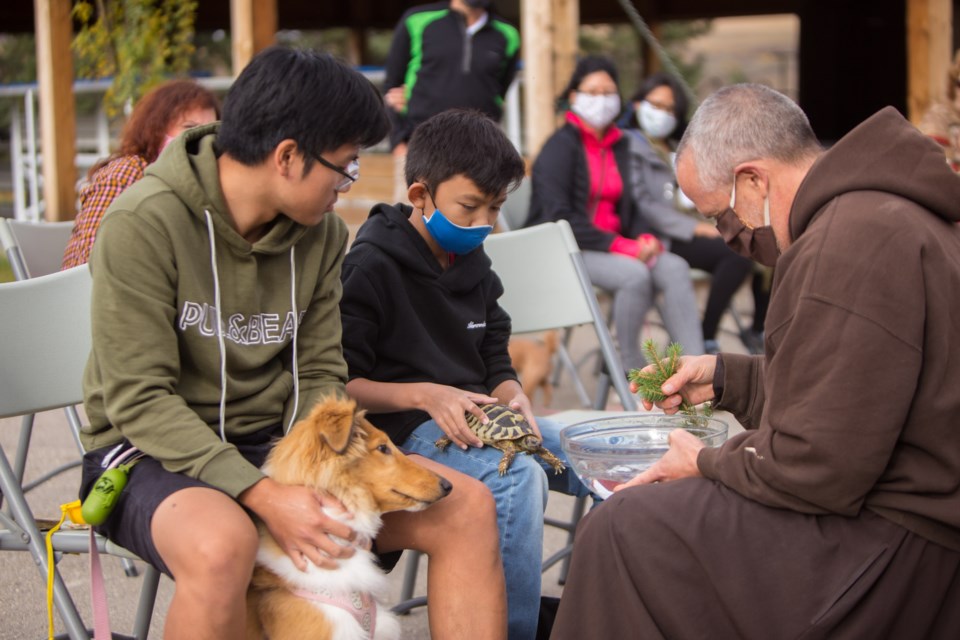 Josh Depositar and his puppy Skye, left, and Zach Depositar and  his tortoise Kiwi are blessed by Father Dan Gurnick during the Blessing of the Animals at the Mount St. Francis Retreat Centre on Sunday (Oct. 4). During the special ritual outside people were able to bring their pets to receive a blessing from one of the Friars. The day was inspired by St. Francis who gave special consideration to all of God's creatures, calling them brothers and sisters. (Chelsea Kemp/The Cochrane Eagle)