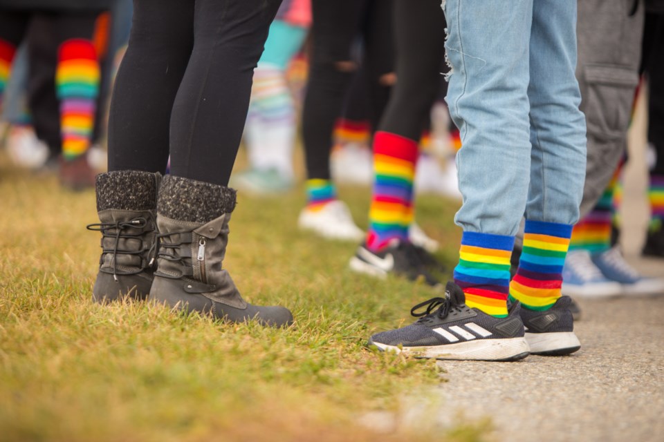 Cochranites walk a student who was bullied for wearing rainbow socks home during the Rainbow Sock Walk on Tuesday (Oct. 13). (Chelsea Kemp/The Cochrane Eagle)