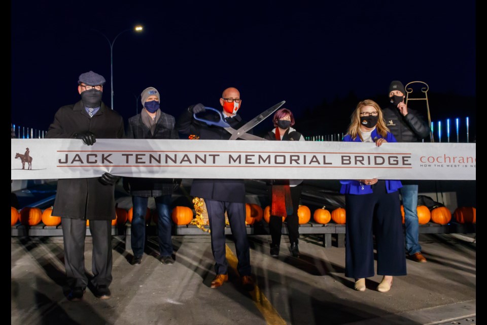 Mayor Jeff Genung cuts the ribbon officially opening the Jack Tennant Memorial Bridge to the public on Thursday (Oct. 15). (Chelsea Kemp/The Cochrane Eagle)