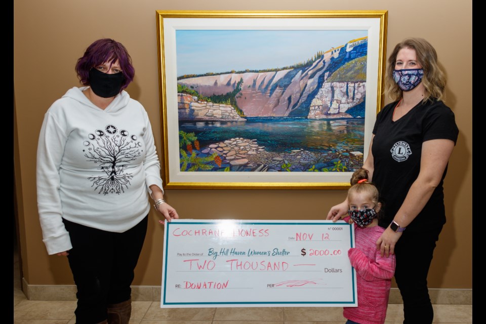 Big Hill Haven Fund Development Officer Tara McFadden, left, receives a Cochrane Lioness Lion Club $2,000 donation from member Kathryn Dunn-Gibbesch and Zoey Bouyers, 5, at Cochrane Toyota on Thursday (Nov. 12). (Chelsea Kemp/The Cochrane Eagle)