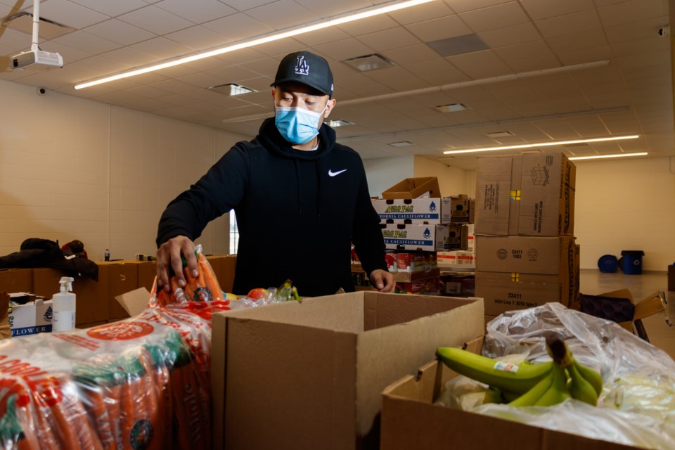 Health promoter Mel Bigstoney prepares food boxes for the Stoney Nakoda Drive-Thru Food Market on Thursday (Jan. 28). (Chelsea Kemp/The Cochrane Eagle)