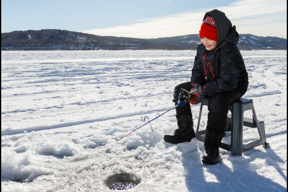 Tristan Brown, 10, ice fishes at Ghost Lake on Feb. 15, 2021. (Chelsea Kemp/The Cochrane Eagle)