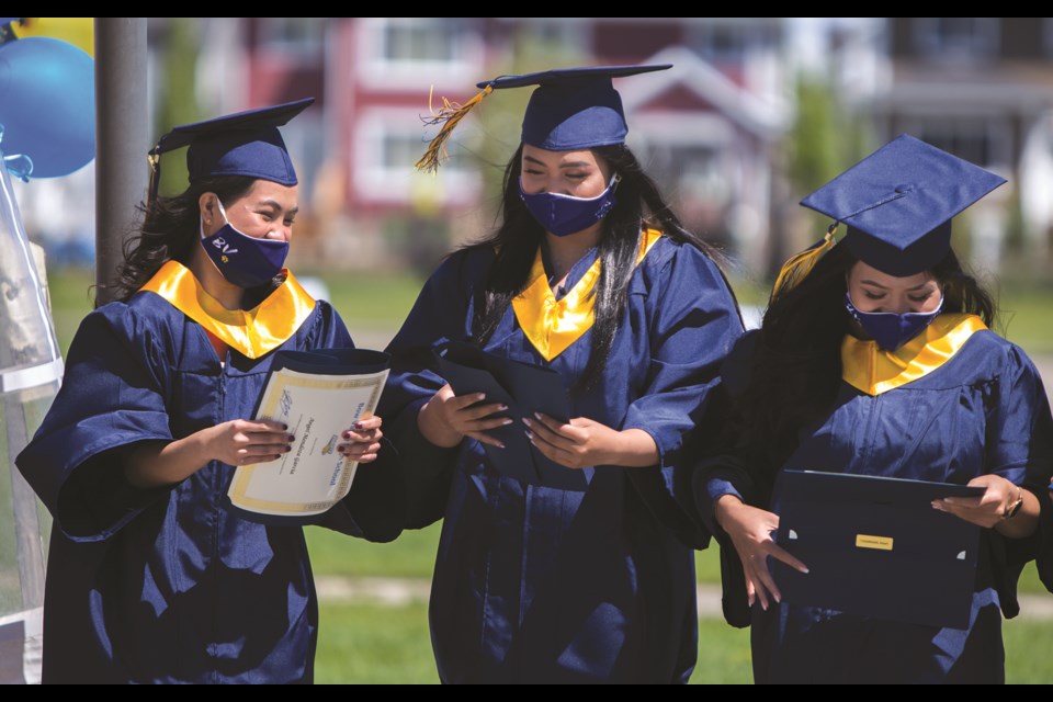 Angel Garcia, left, Marie Tapulao and Heart Pagarigan attend the Bow Valley High School Class of 2021 graduation on June 12. Graduates and their families were able to participate in a drive-thru graduation throughout the day where small groups gathered to receive their diplomas. (Chelsea Kemp/The Cochrane Eagle)