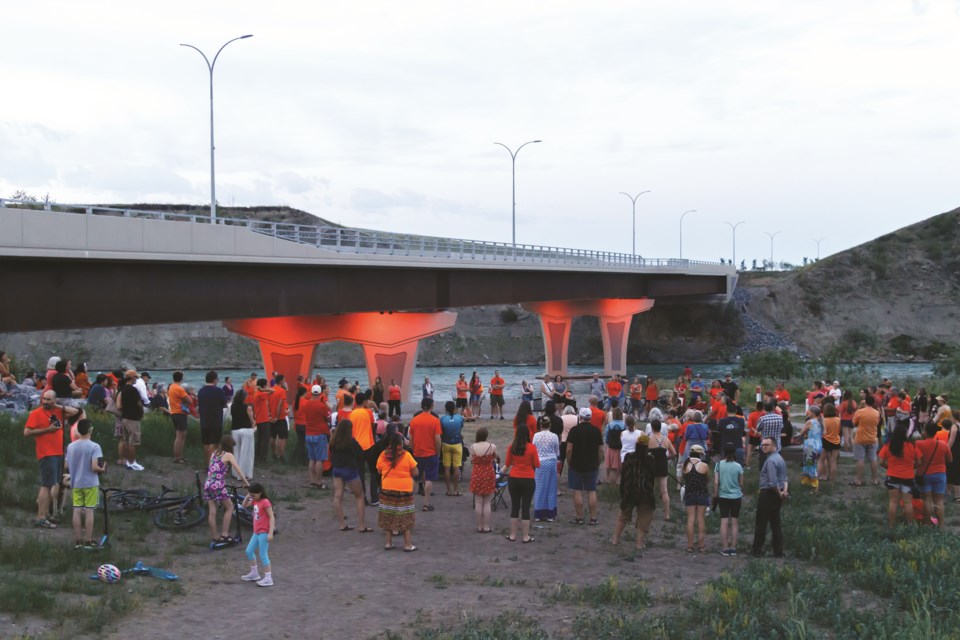 Teresa Snow speaks at vigil honouring children found in unmarked graves at former Residential Schools on Thursday (July 1) at the Jack Tennant Memorial Bridge. The bridge lights were lit orange in the childrenâs memory. (Chelsea Kemp/The Cochrane Eagle)