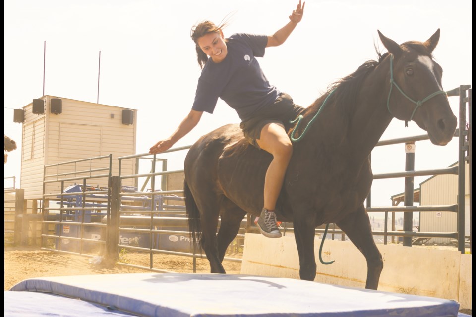 Beky Cardinal falls from her horse at the Stunt Nations workshop at the Cochrane and District Ag Society on Tuesday (July 13). (Chelsea Kemp/The Cochrane Eagle)