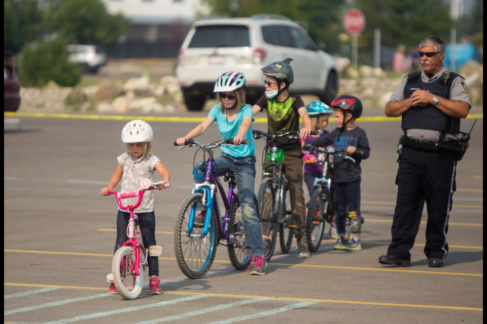 Youth prepare to ride through the safety course at the Kiwanis Club of Cochrane and Bike Cochrane organized Free Bike Day at the LaunchPad Flow Park on Saturday (July 24) in the Garmin parking lot. The day included the official grand opening of the LaunchPad, bike tune-ups, helmet inspections, a safety course and other fun activities for Cochrane youth. (Chelsea Kemp/The Cochrane Eagle)