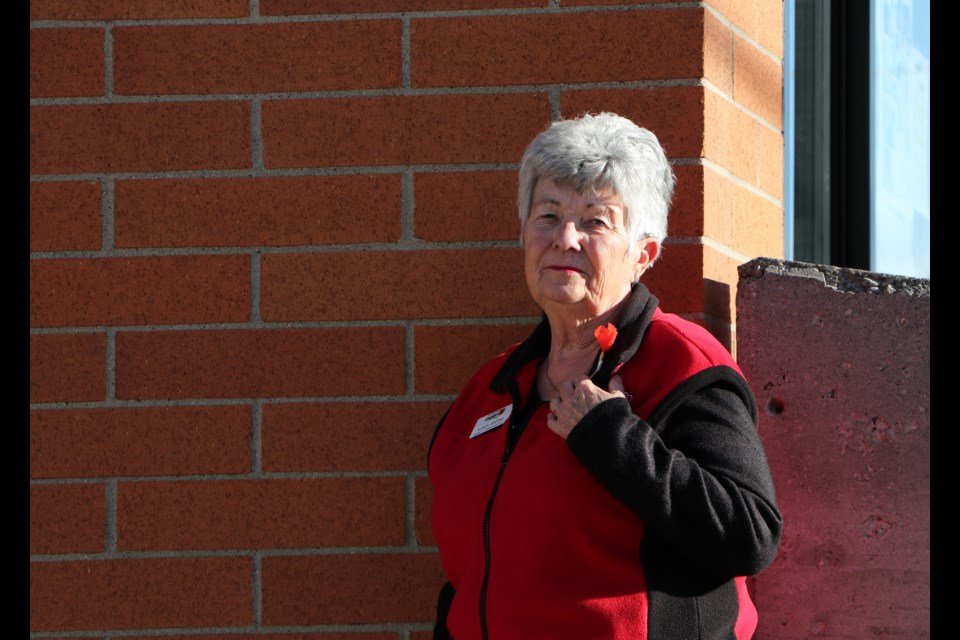 Karen Bruens, Royal Canadian Legion Cochrane Branch #15 president and District 5 Commander stands outside the Legion Nov. 2 wearing a commemorative replica poppy pin available for the 100th anniversary of the poppy in Canada. (Jessica Lee/The Cochrane Eagle)