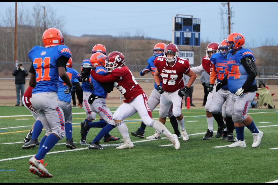 Cobras players take down the Bulldogs offence in the ASAA provincial semi-final game at Spray Lakes Legacy Field Nov. 12. (Jessica Lee/The Cochrane Eagle)