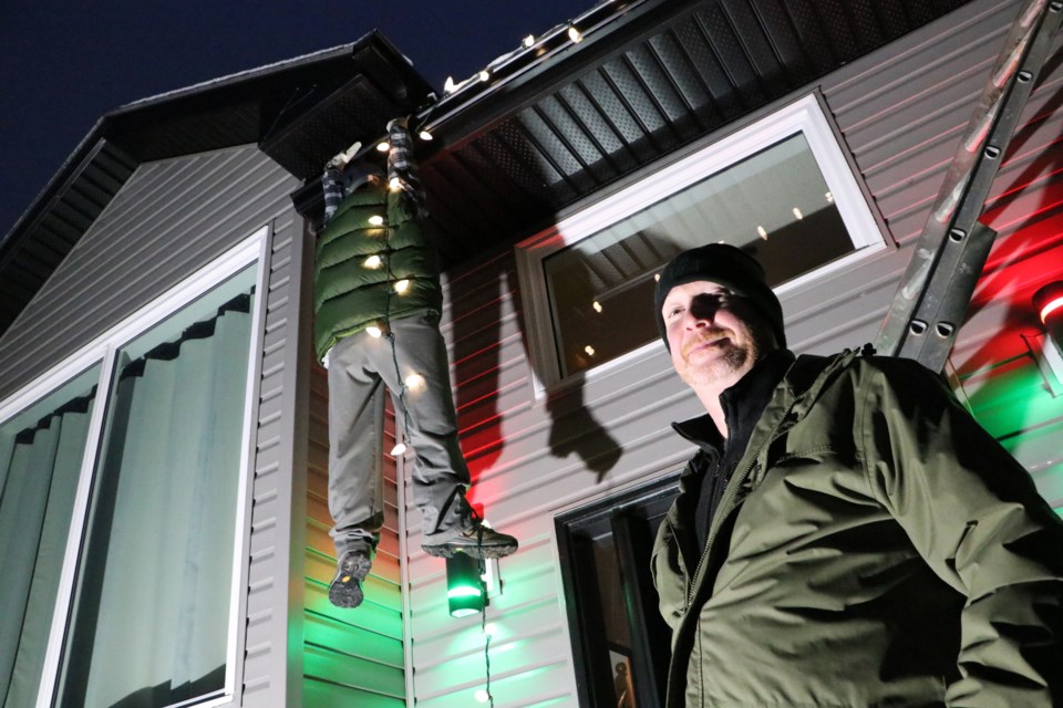 Steve Potter, a resident of Cochrane, set up his holiday decor this year in homage to an iconic scene in National Lampoon's Christmas Vacation. His remake of the character Clark Griswald includes hands that Potter welded himself to keep Griswald clinging to the eavestrough, even on the windiest of days. (Jessica Lee/The Cochrane Eagle)