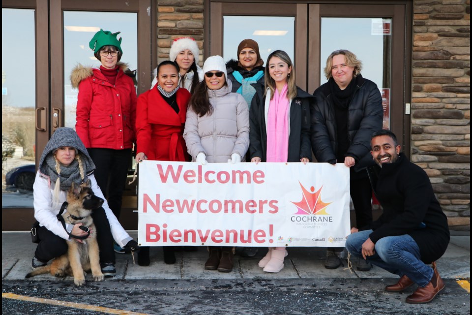 Volunteers of the Cochrane Immigrant Services Committee's Jingle Mingle event pose outside Cochrane Alliance Church Dec. 3 before a meeting to plan the Christmas Day event. (Jessica Lee/The Cochrane Eagle)