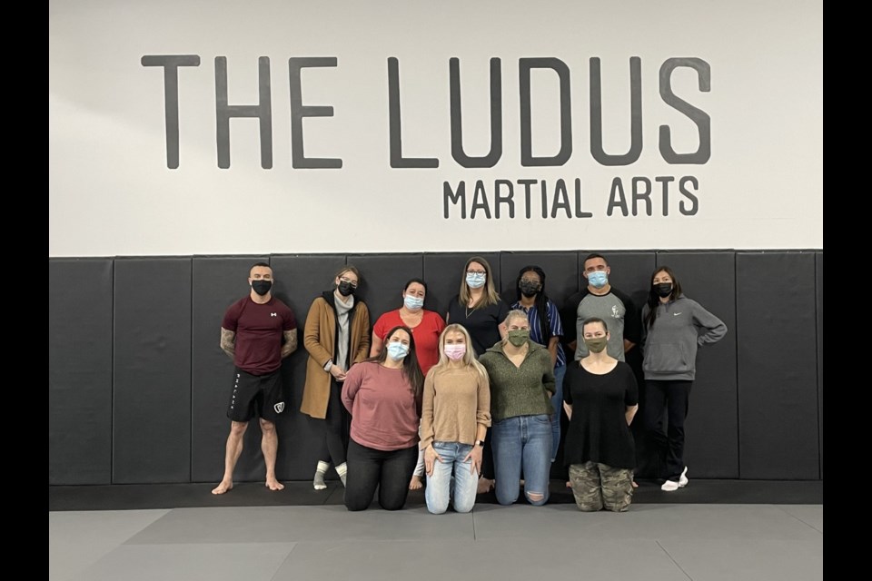 The Ludus Martial Arts Training Academy youth kickboxing coach and professional MMA fighter Nick Felber, left, gathers for a photo with gym owner/founder Justin Sander, second from right, and staff from the Bent Arrow Traditional Healing Society in Edmonton. The two organizations have partnered up to build a culturally aware self-defence program for Indigenous women and girls taught out of the gym. (Photo Submitted)