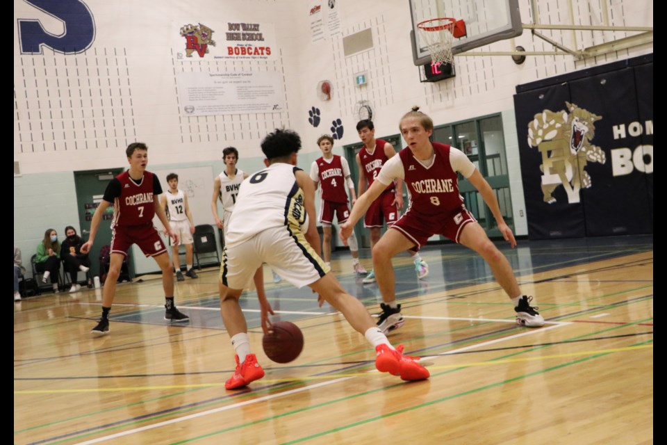 Bobcats Paulo C. looks for an opening past Cochrane High Cobras Evan Sim in a match up at Bow Valley High School Feb. 1. (Jessica Lee/The Cochrane Eagle)