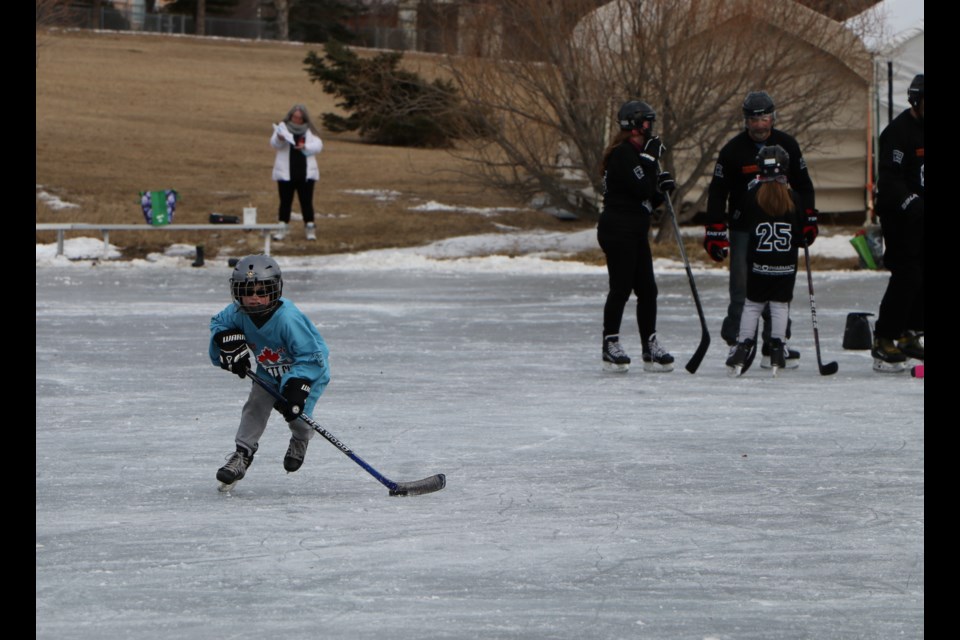 A young boy skates the puck up the ice at the mini Mitford Pond at the 14th annual Kimmett Cup. (Jessica Lee/The Cochrane Eagle)