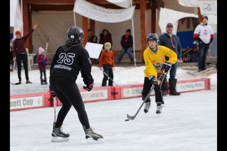 The Toefield Fighting Snowgeese (black) face go up against We Are Family (yellow) in a playoff quarterfinal game at Mitford Pond for the 14th annual Kimmett Cup Feb. 5. (Jessica Lee/The Cochrane Eagle)