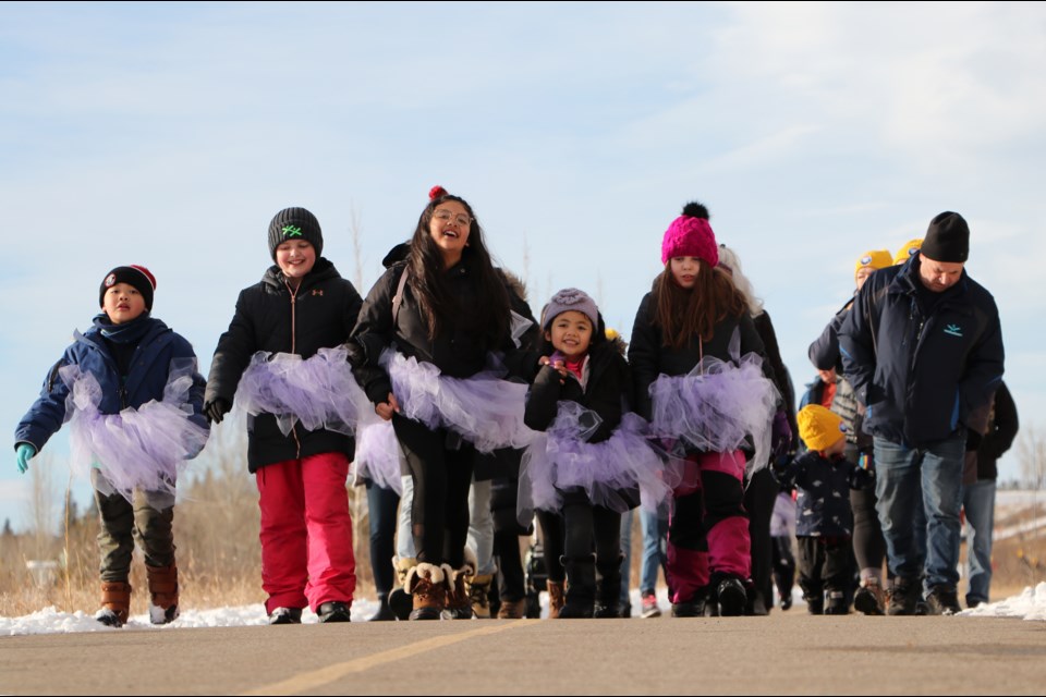 Kids in purple tutus representing Big Hill Haven walk the path heading east through Riverfront Park for Coldest Night of the Year Feb. 26. (Jessica Lee/The Cochrane Eagle)