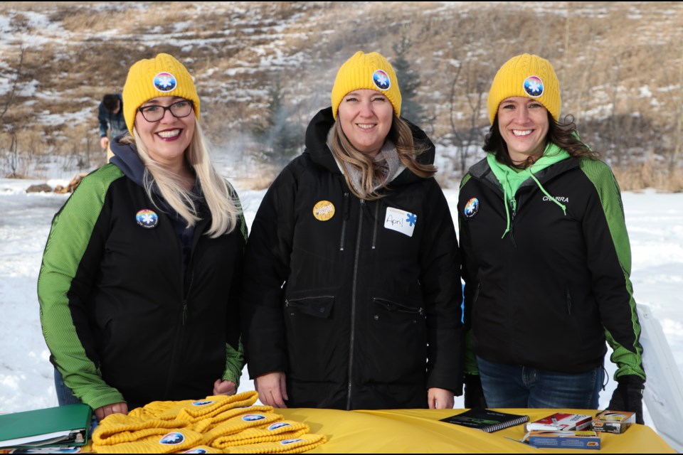 Helping Hands former executive director, Chairra Nicolle, right, recently left the non-profit to take on the coordinator role with Family and Community Support Services. Here she is pictured with Helping Hands programs manager Melia Hayes, left, and food security programs manager April Baird at the registration table at this year's Coldest Night of the Year walk at Riverfront Park Feb. 26. (Jessica Lee/Cochrane Eagle)