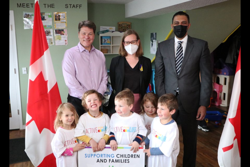 Richard Monette, head of the Active for Life initiative, top left, Federal Minister of Families, Children and Social Development Karina Gould, middle, and Calgary-Skyview MP George Chahal pose for a photo with some of the children at Future Stars Daycare April 22 after making an announcement about dedicating funding for a national project aimed at helping families benefit from innovative early learning and child care practices. (Jessica Lee/The Cochrane Eagle)