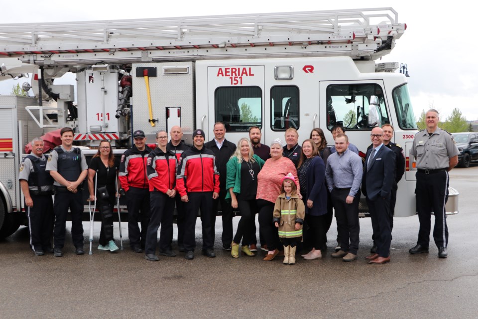 Cochrane Fire Services administrative assistant Dot Gillis, members of her family, Town staff and Protective Services Centre staff stand in front of the Cochrane Fire Services Aerial 151 truck. As part of her retirement celebration, fire chief Shawn Polley took Gillis for a trip up in the bucket of the ladder truck. (Jessica Lee/The Cochrane Eagle)