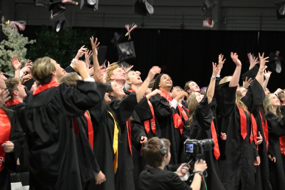 The Cochrane High graduating class of 2022 throws their caps in the air at their convocation ceremony at Spray Lake Sawmills Family Sports (SLSFSC) Centre June 3. (Jessica Lee/The Cochrane Eagle)
