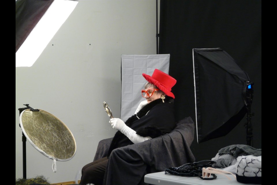 A resident of Big Hill Lodge tries on various accessories at the Fun Photo Shoot event hosted by Route 22 Artist Collective Gallery as part of their community outreach programming. (Photo Submitted/Route 22 Artist Collective Gallery)