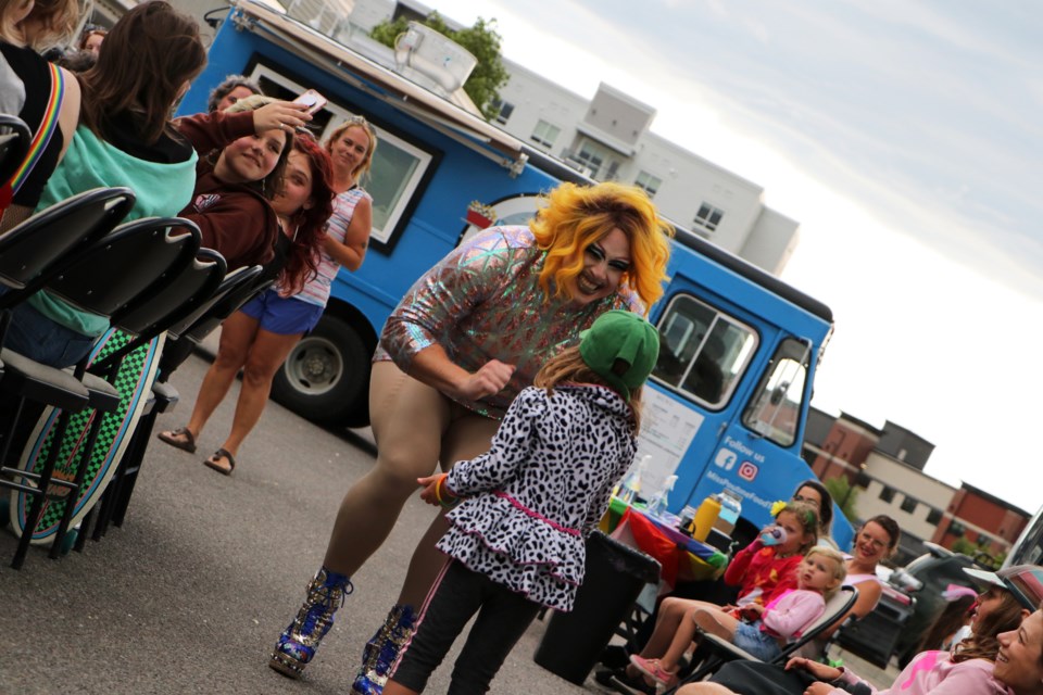 Drag queen Penny Tense interacts with a young audience member at BGC Cochrane and Area's 2nd annual drag show outside The Club teen drop-in space Aug. 26. 